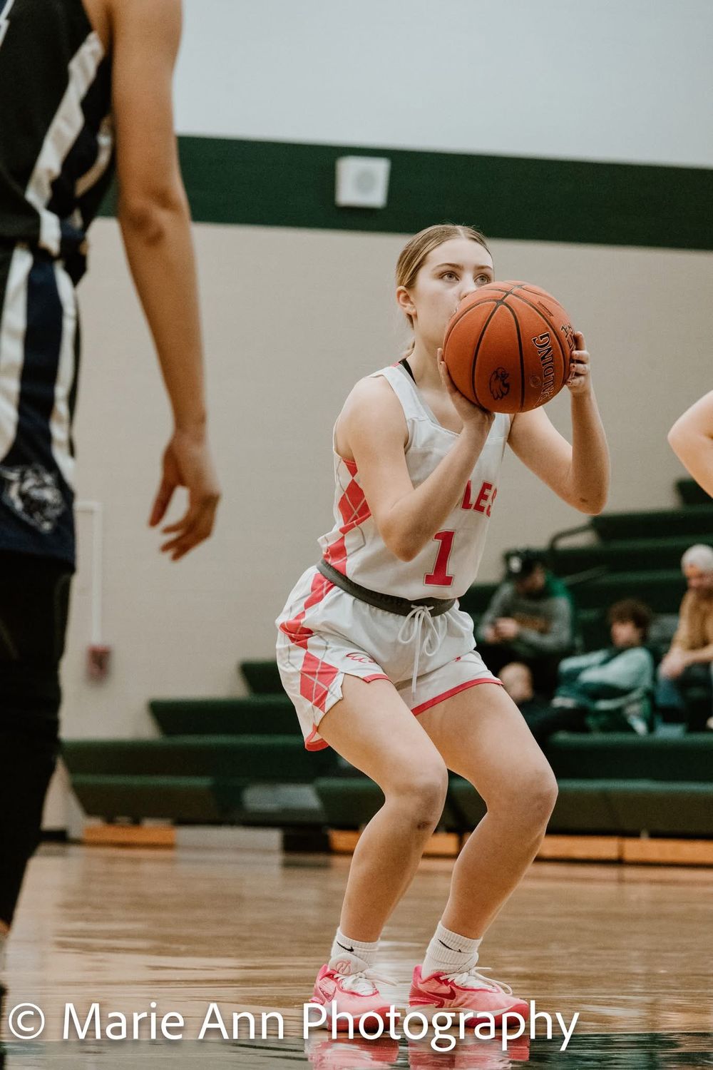 Female basketball player #1 preparing to shoot a free throw during a gym game.