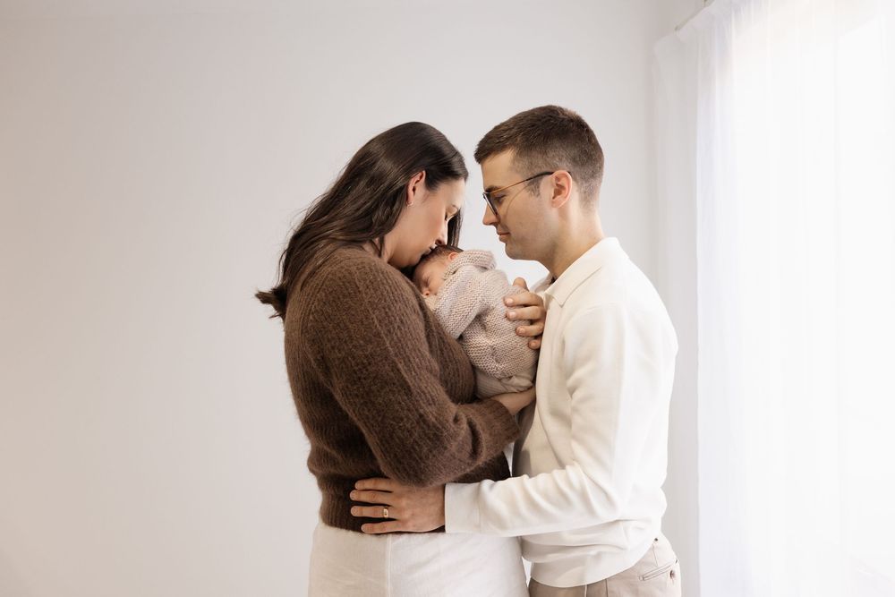 Mum and dad holding baby close during newborn session in bishopdale studio