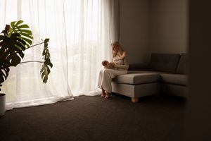 In home newborn session in Christchurch, cuddling mum on the sofa