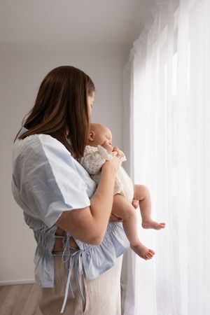 First time mum holding her 10 week old baby during studio newborn session in Bishopdale