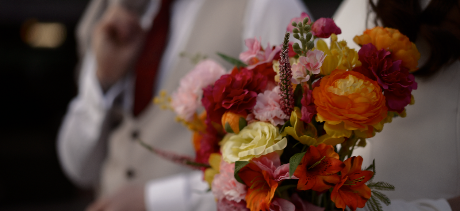 Vibrant autumn-colored wedding bouquet with red and orange flowers.