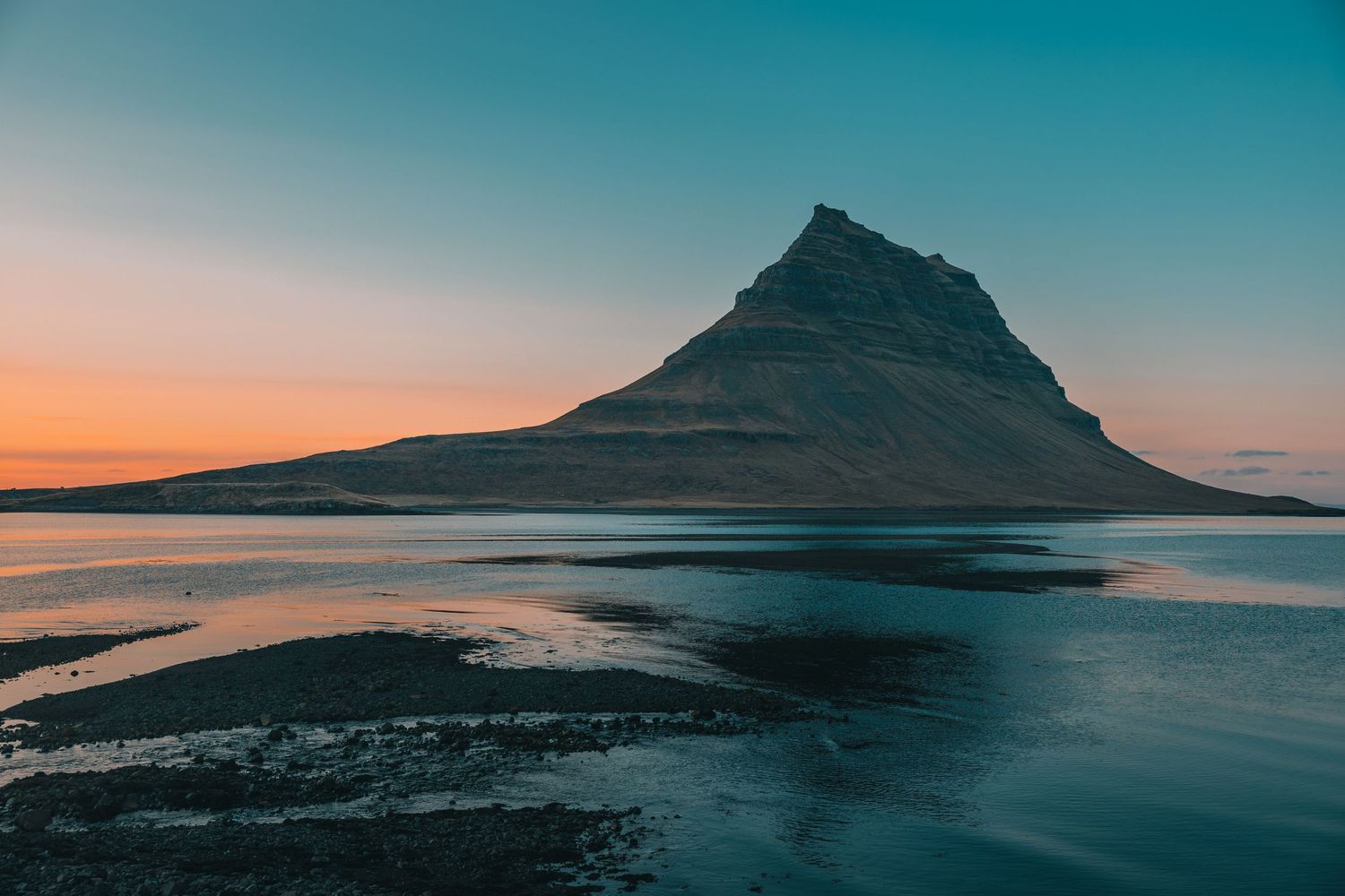Panoramic landscape series of a mountain reflected in calm waters during sunset.