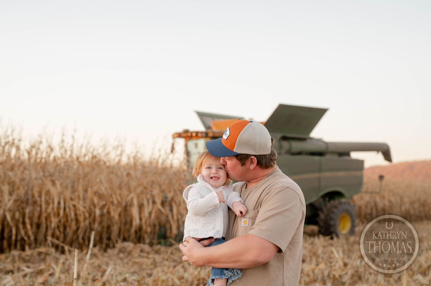 Sweet moment shared in front of a combine harvester in a cornfield.