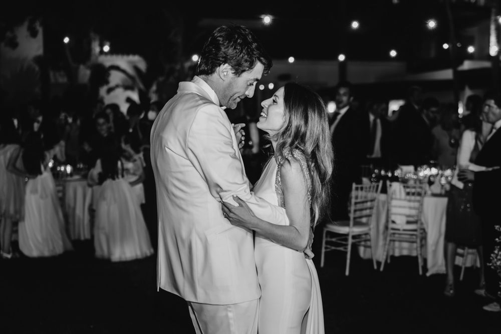 A black and white photo of a couple dancing close together at an elegant wedding reception.