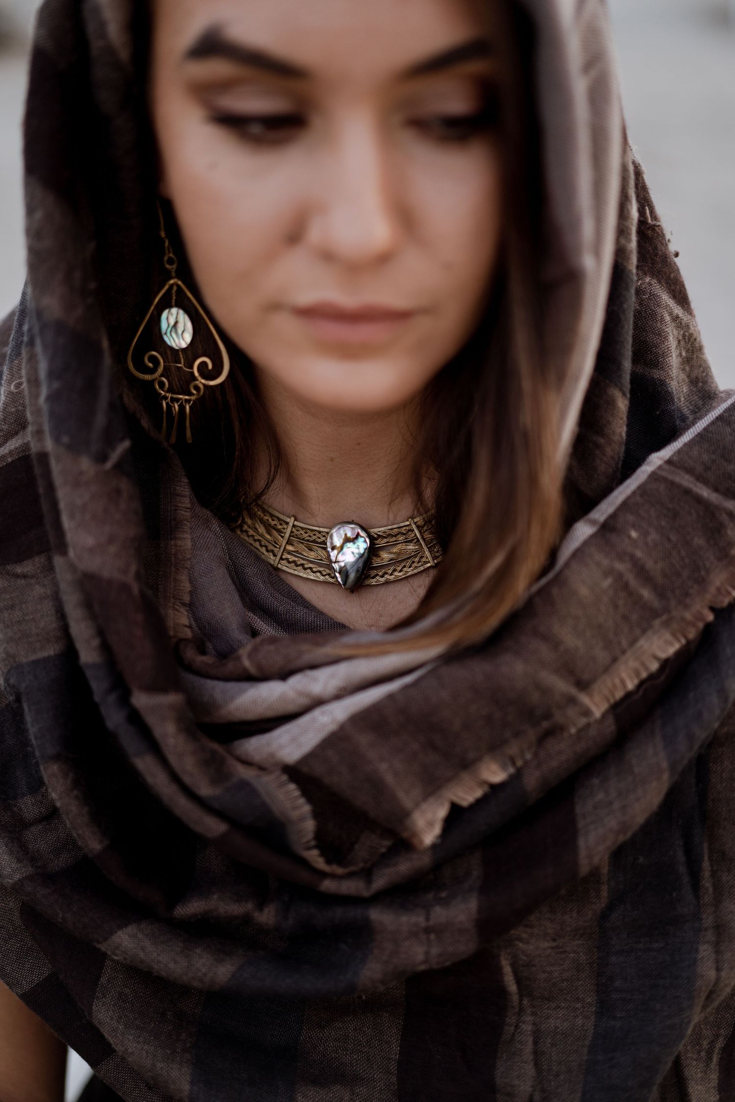 Fotografia di dettaglio per artigiana pugliese con collana e orecchini realizzati a mano in ottone e pietre preziose in madreperla