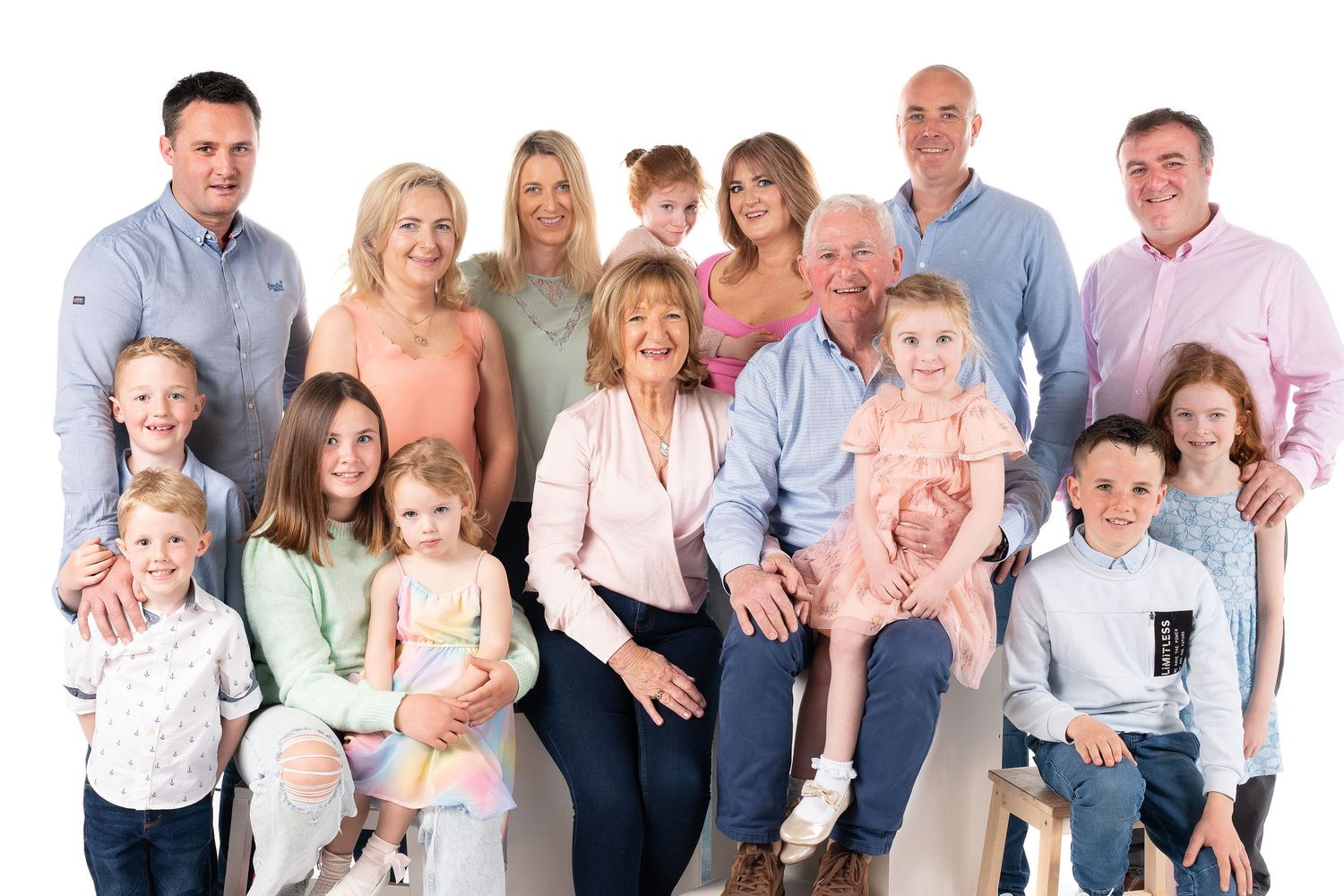 A horizontally tiled sequence of family portraits showing large groups in matching casual attire against a white background.