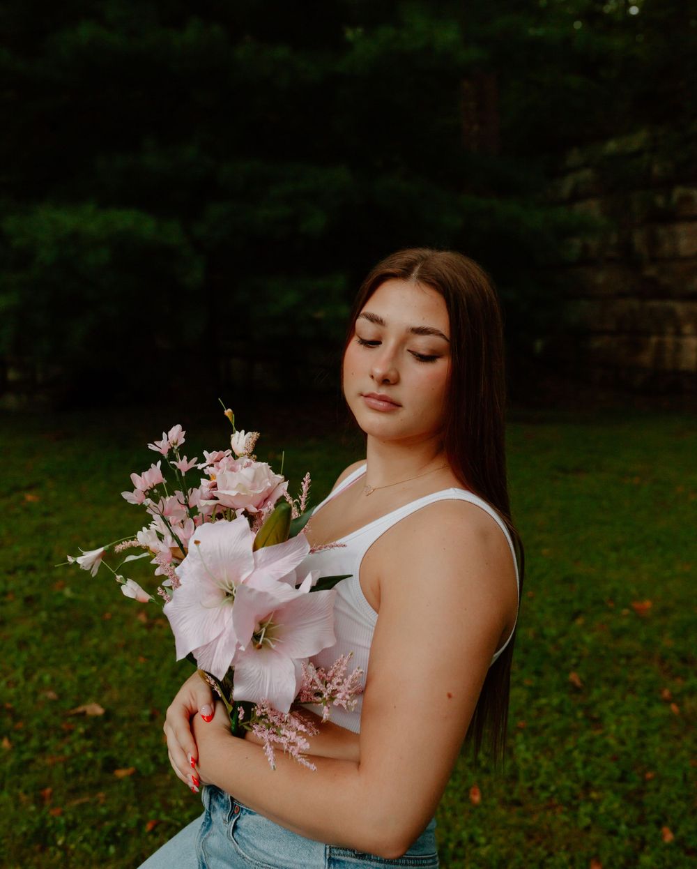 Romantic portrait session with pink lilies and soft lighting in a garden setting.