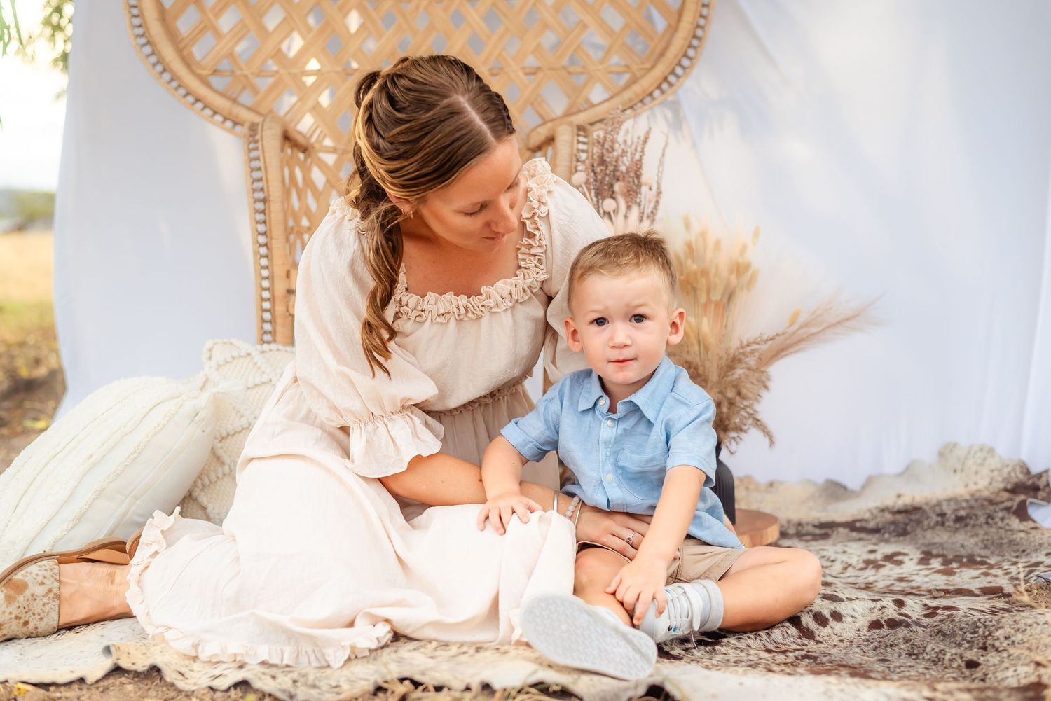 A candid moment of parent and child sitting together on a wicker chair with floral decorations.