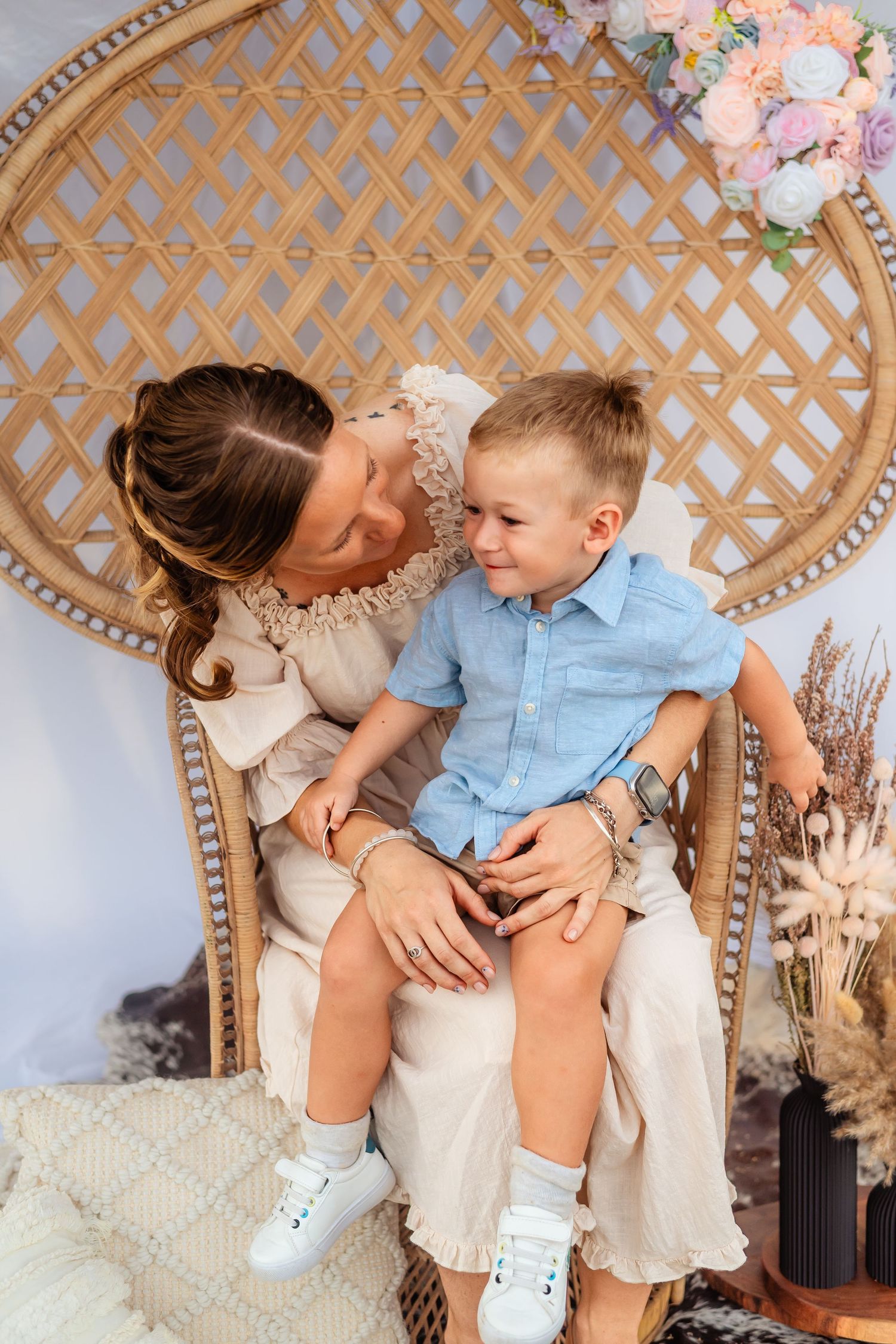 An intimate portrait of parent and child sharing laughter while sitting in a decorated setting.
