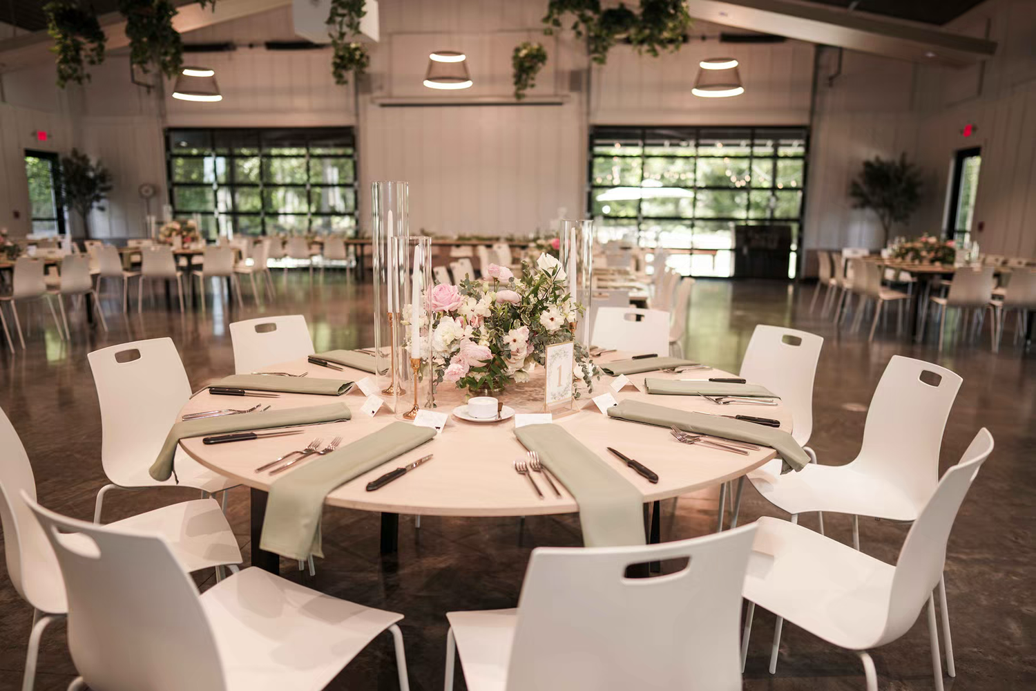 Retreat 21 Wedding Venue interior with white chairs and round tables arranged in a spacious dining area.