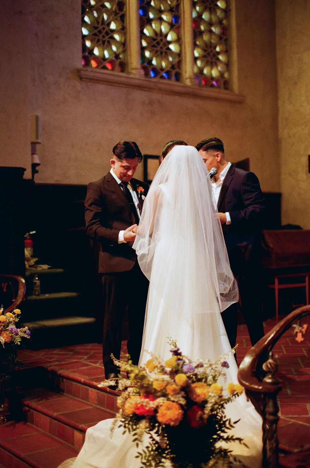 Film photograph capturing the stunning, complex colors and grain of a wedding ceremony and vow exchange inside a chapel in Santa Barbara.