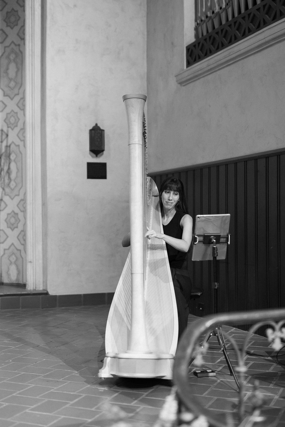 A black and white photo of a harpist playing at a Santa barbara wedding