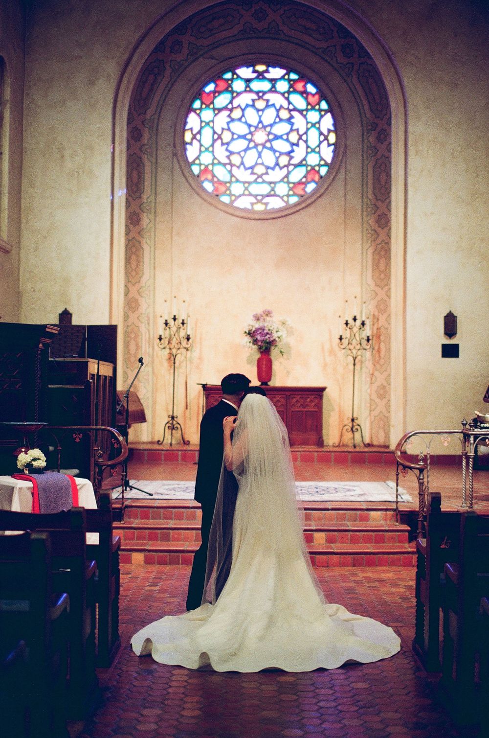 Film photograph capturing the stunning, complex colors and grain of a couple's portrait inside the historic Unitarian Society of Santa Barba