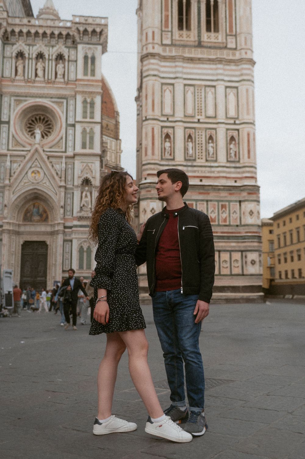 Couple posing in front of Florence's iconic Duomo cathedral on a cloudy day.