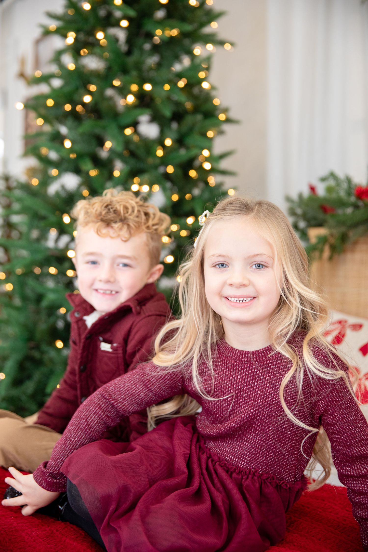 Middletown Christmas mini session featuring two kids smiling on bed Christmas portraits with cozy pajama styling and warm festive indoor pho