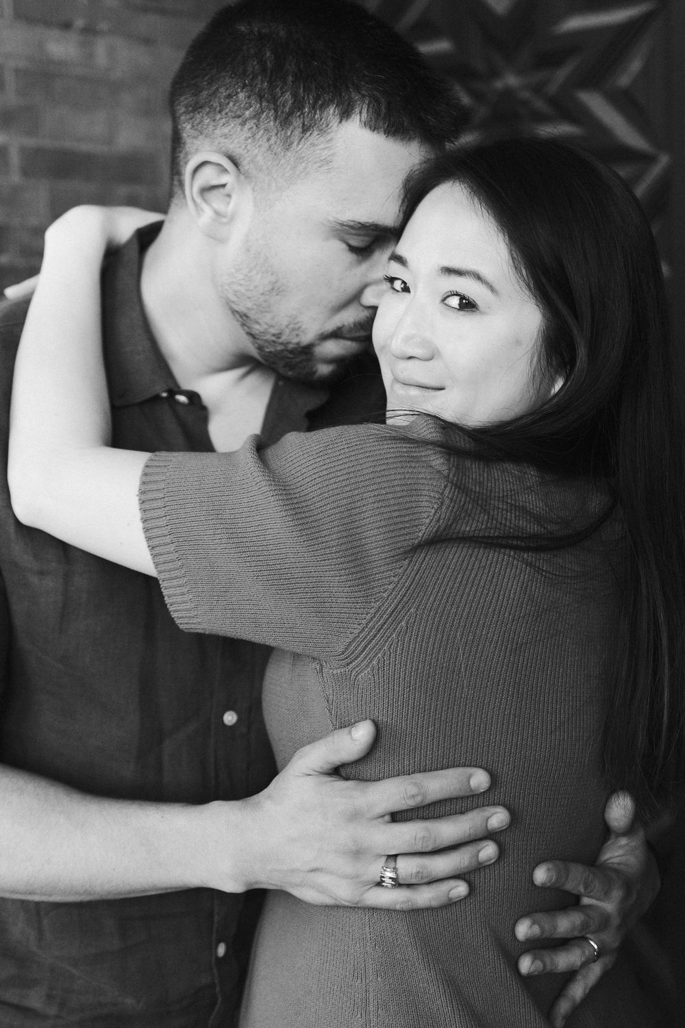 Black and white photo series showing a tender embrace between two people in an intimate moment.