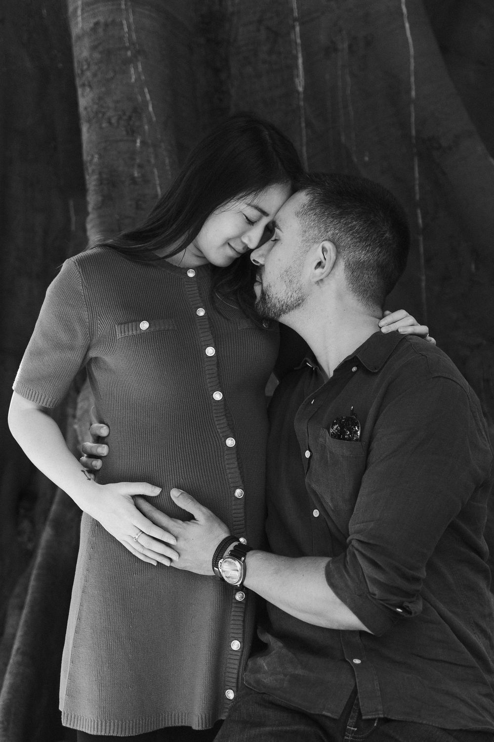 Black and white romantic maternity photo sequence showing couple embracing in tender moments.