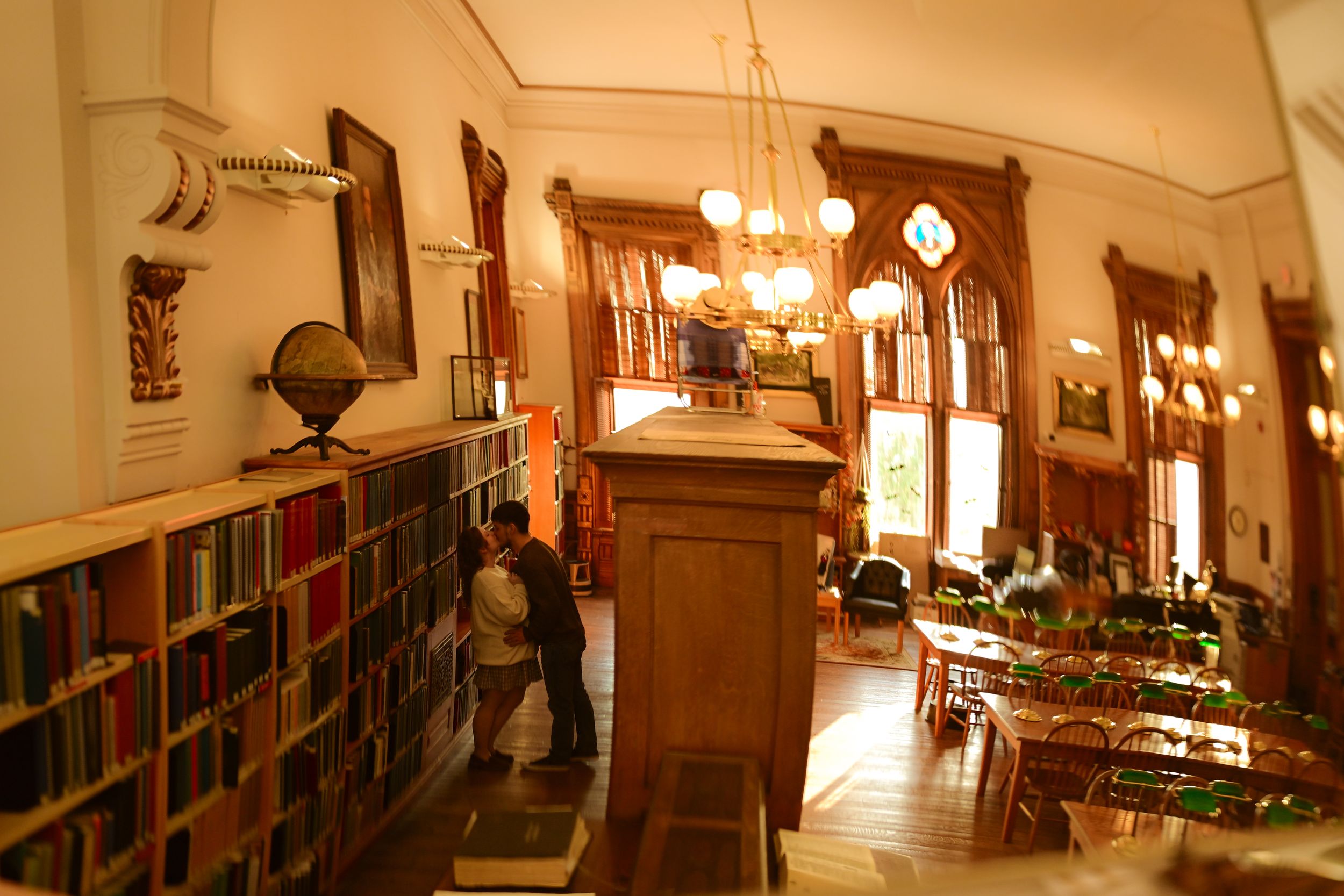 Elegant hallway with wooden bookshelves, chandelier lighting, and classic architectural details in a historic building.