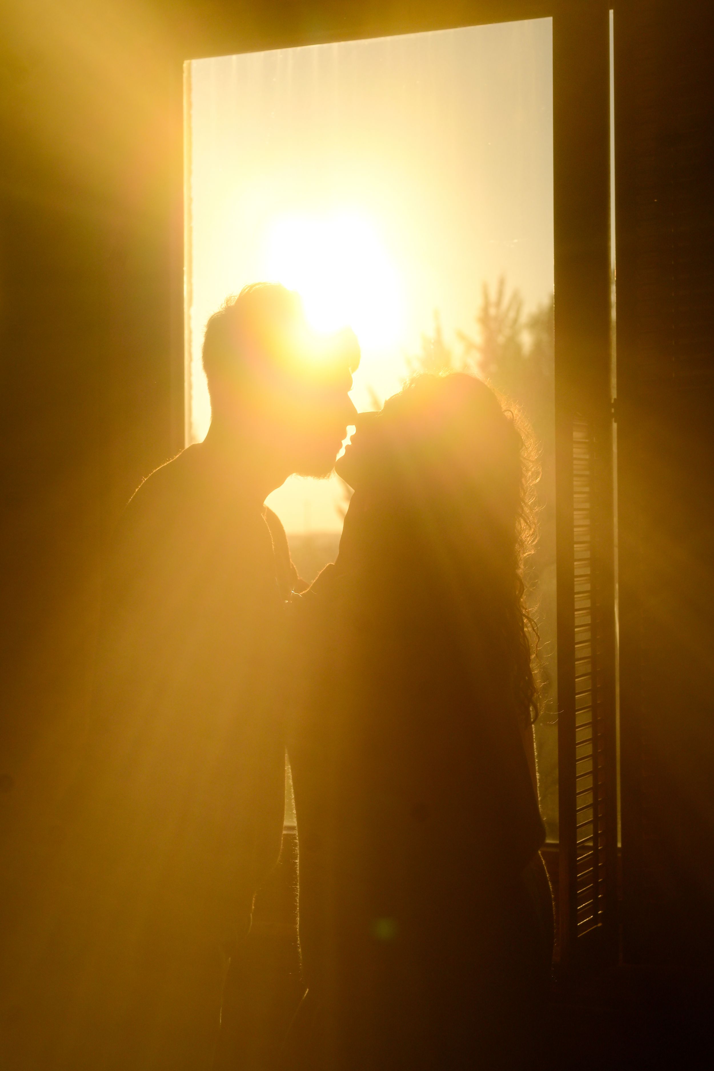 Silhouette of a person in front of a bright golden light creating a dramatic backlit effect.