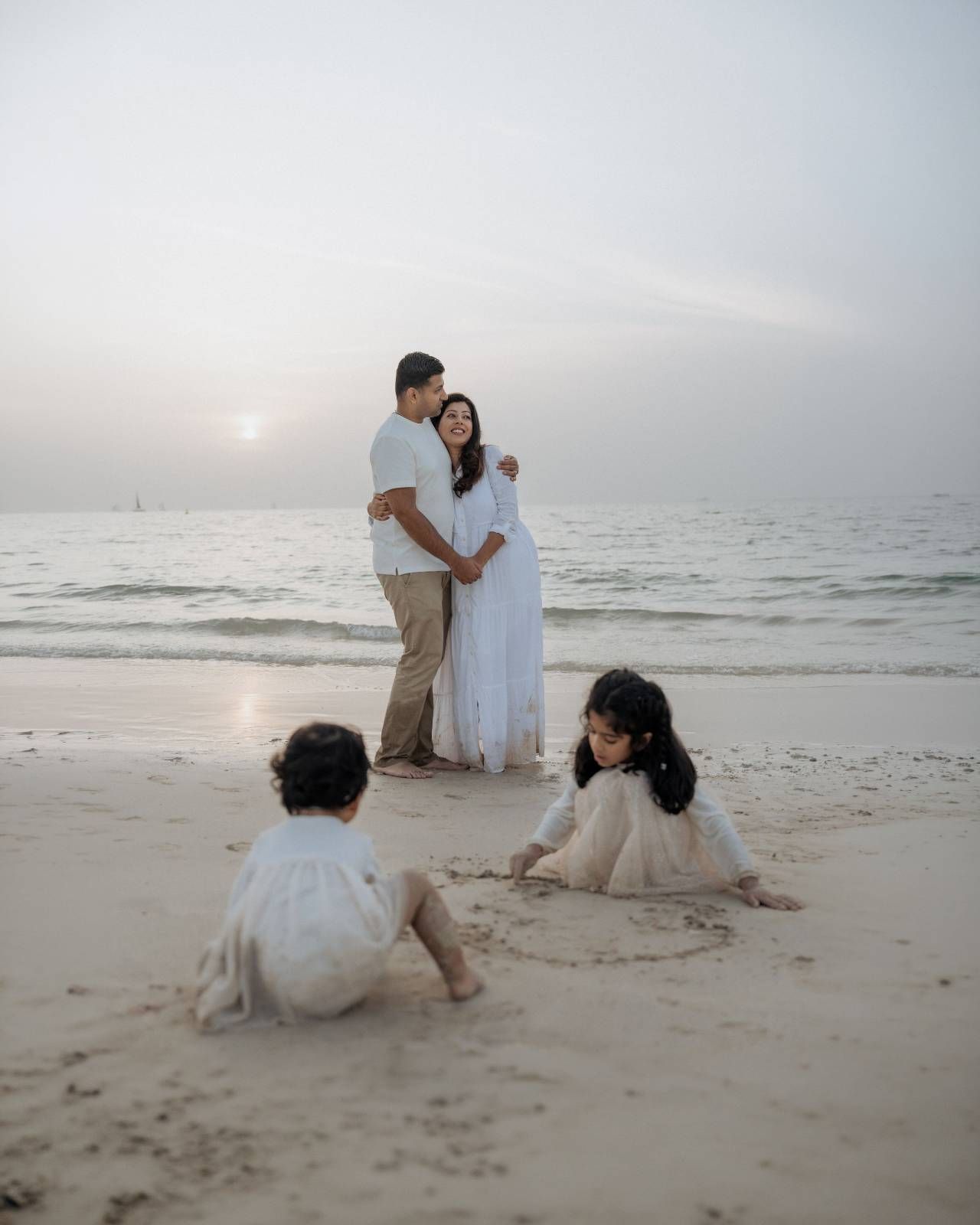Family enjoying quality time together on sandy Dubai beach at sunset