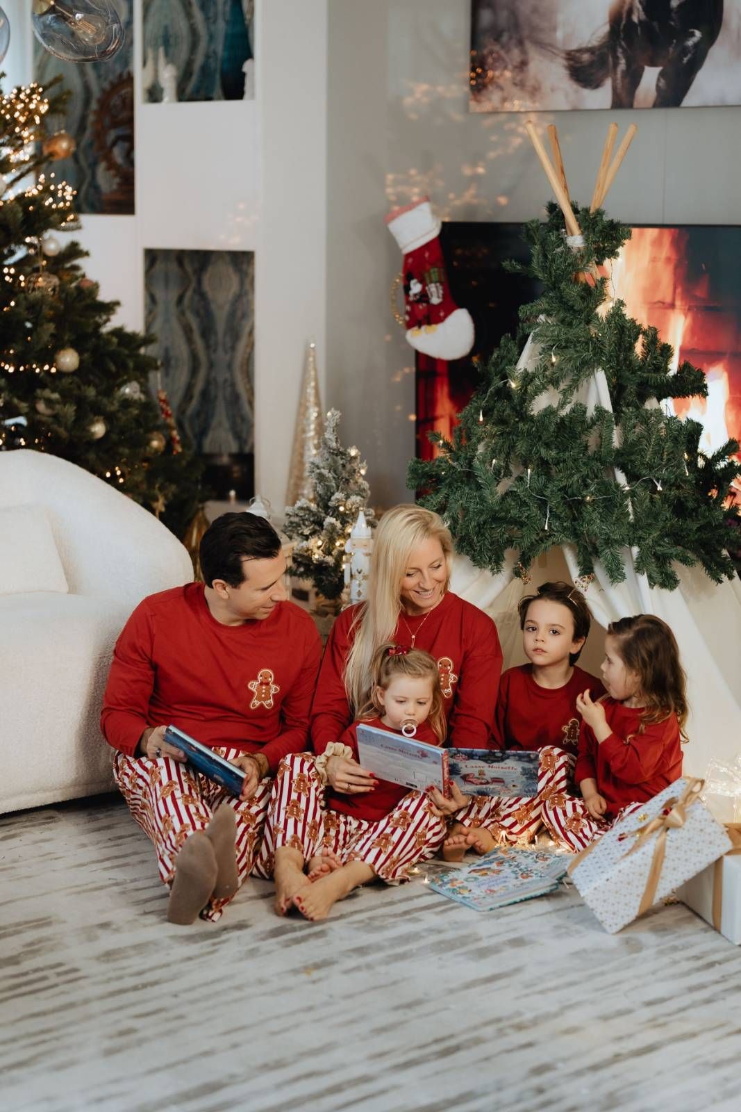 Family celebration moment with Christmas tree and festive red decorations indoors