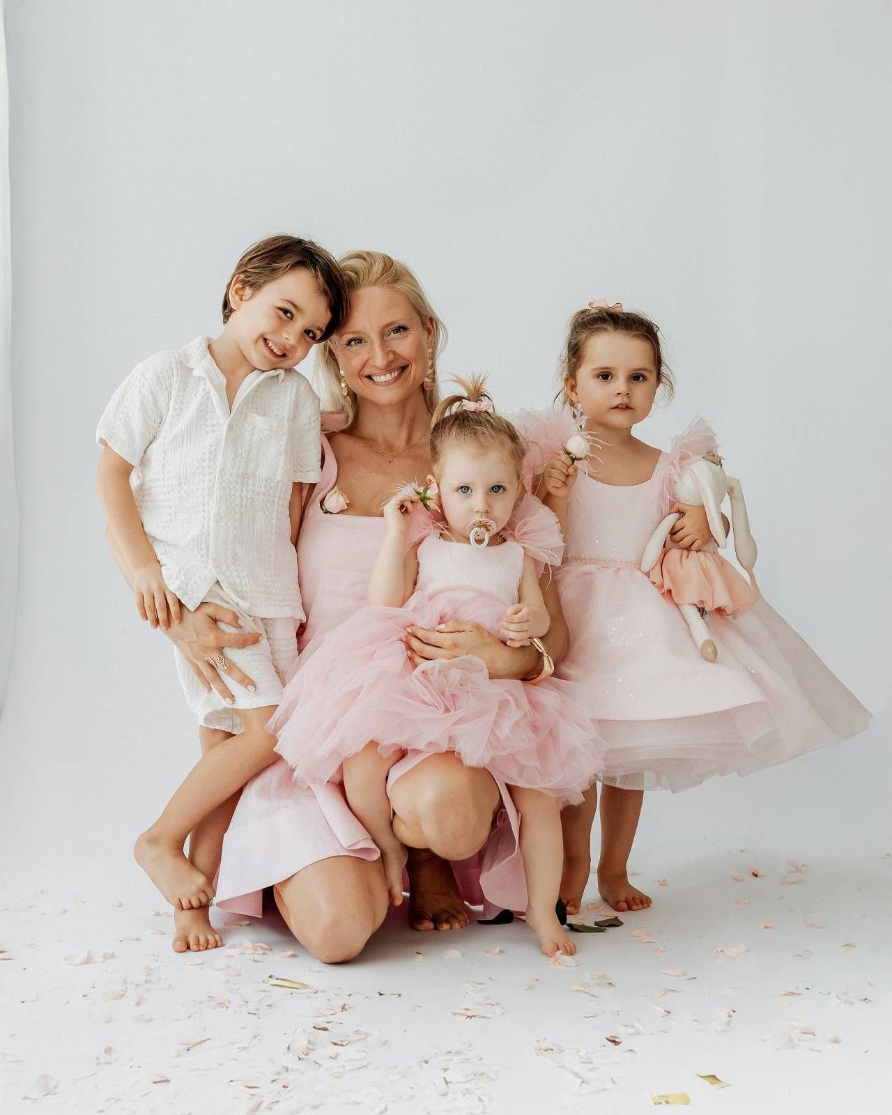 Family of five in matching cream and white outfits posing together outdoors in Dubai
