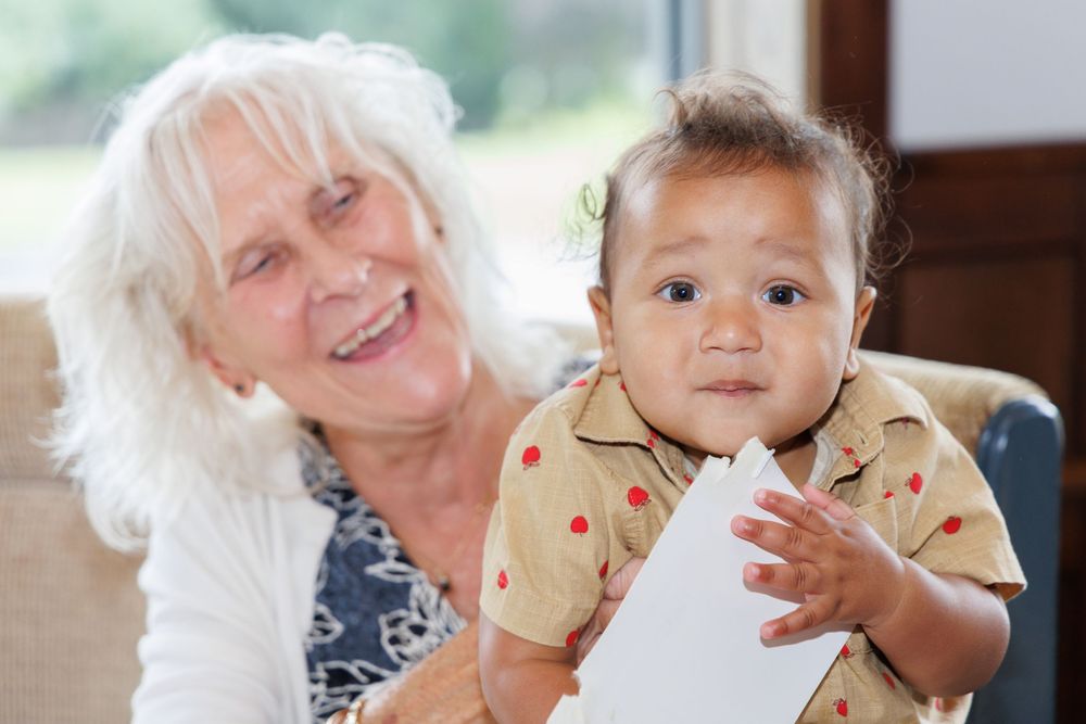 Multi-generational family gathering showing warm embraces and smiles.
