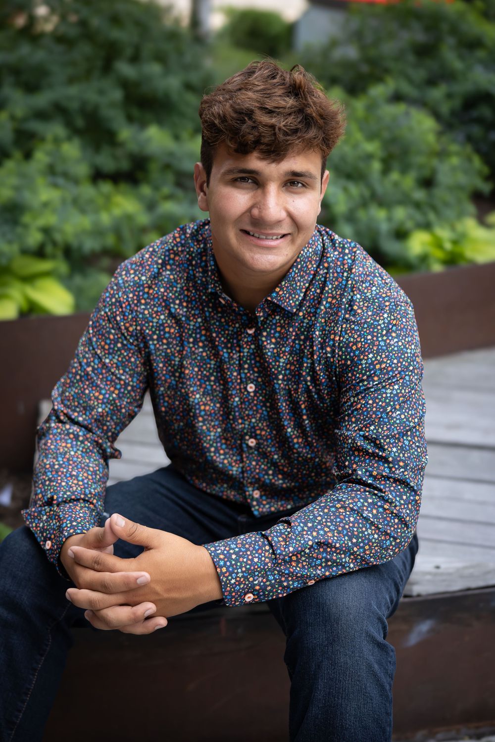 A series of casual outdoor portrait shots showing someone in a floral print button-down shirt and dark jeans.