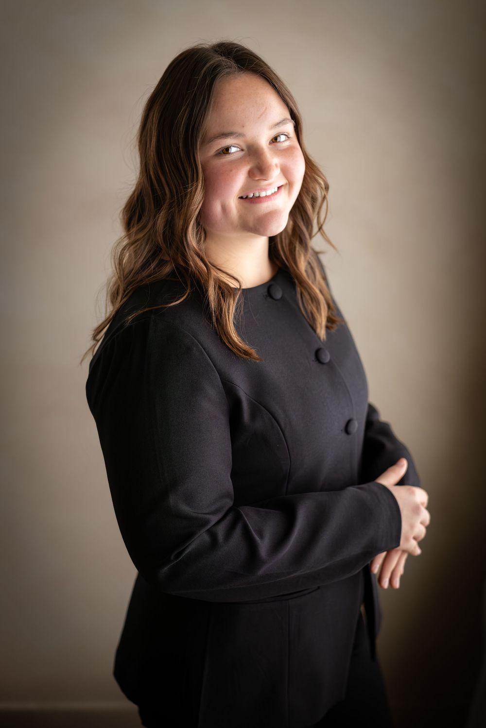 Professional studio portrait of someone wearing a black sweater against a neutral background with soft lighting.