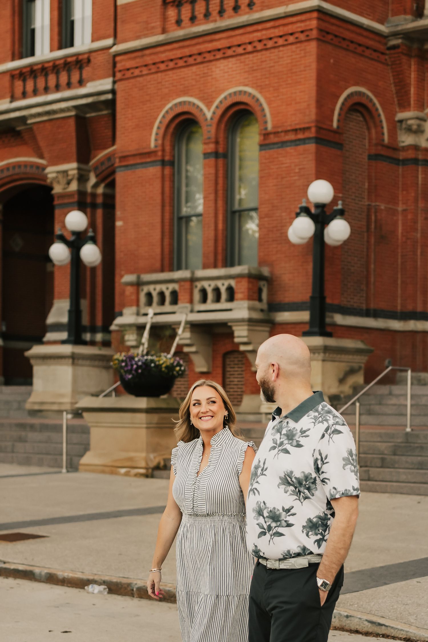 Husband looks lovingly at wife as he leads her across the street in downtown Cincinnati.