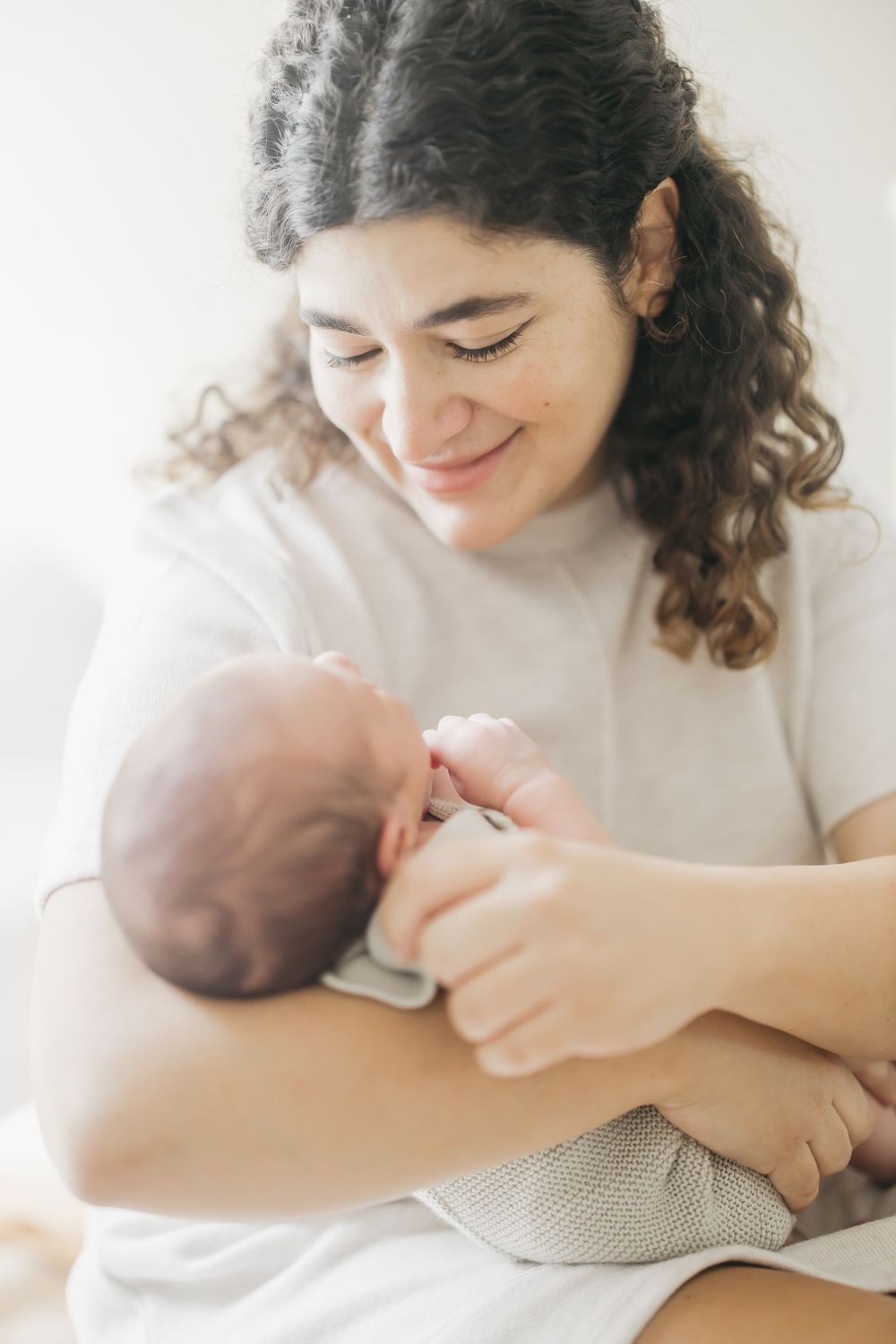 A tender moment of breastfeeding captured in a series of soft, intimate photographs in natural light.