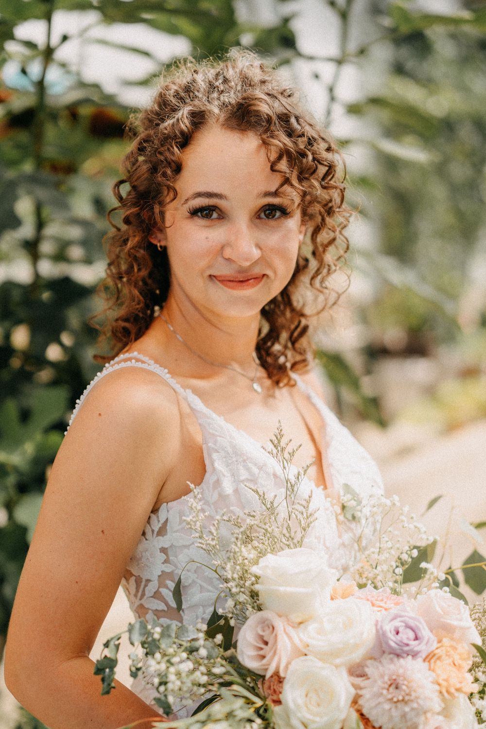 Romantic bridal portraits showcasing a lace dress and natural bouquet against a soft, natural backdrop.