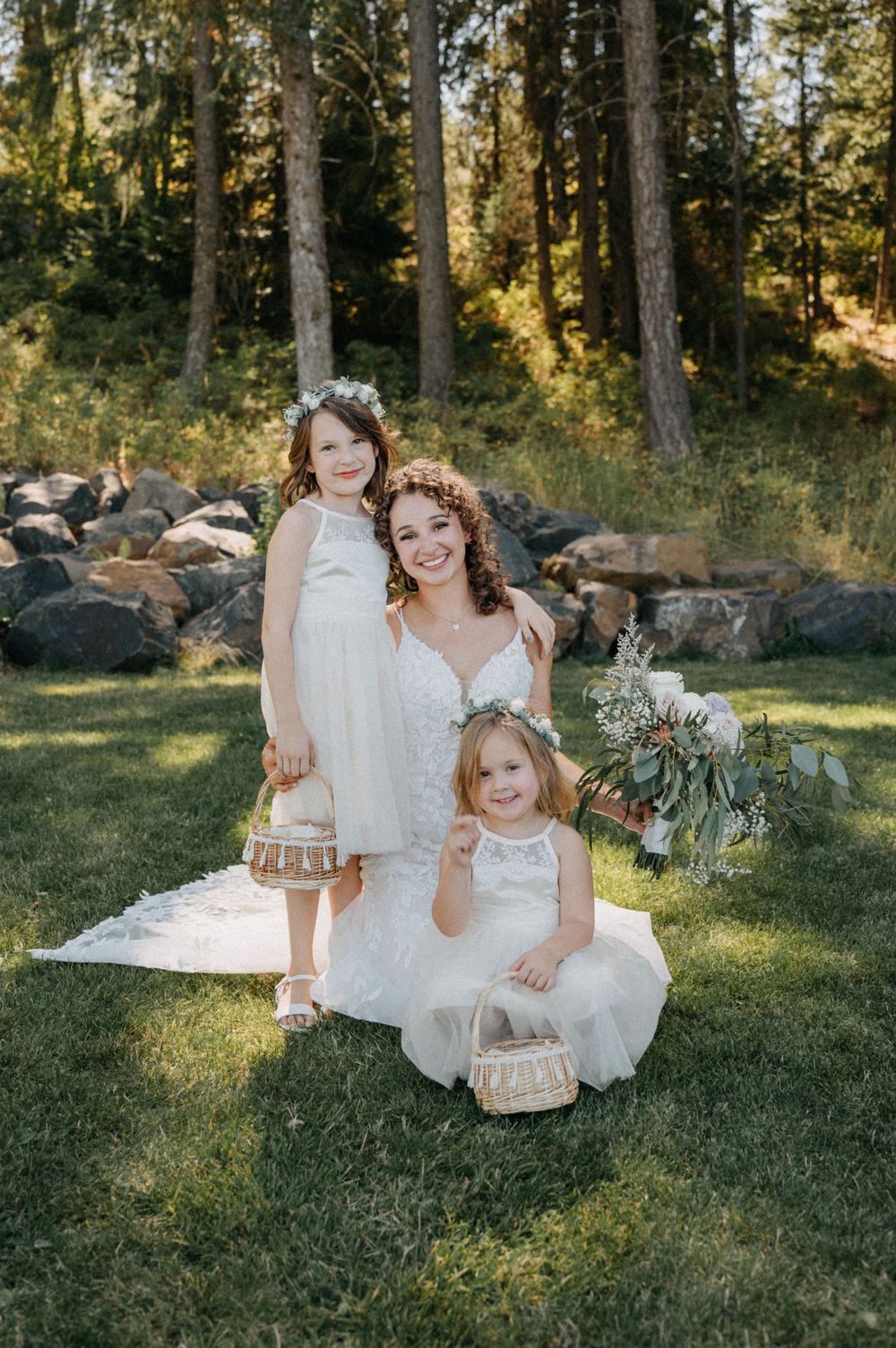 A dreamy outdoor photo session in a wooded area with white dresses and natural sunlight filtering through the trees.