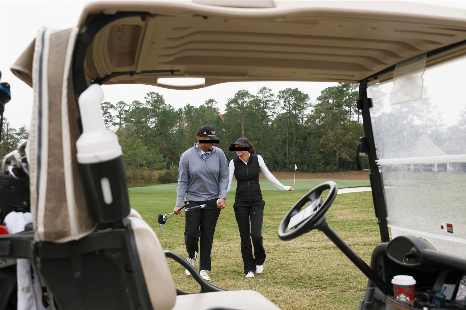 A newly engaged couple holding hands and walking towards their golf cart at Cypresswood Golf Club.