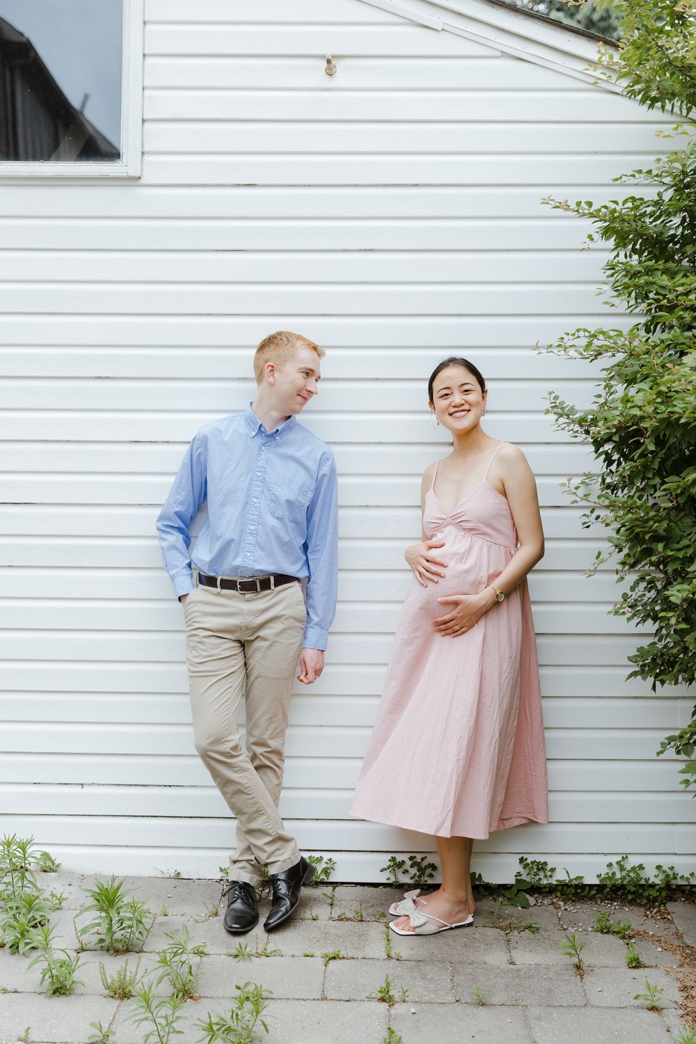 A couple in formal attire poses against a white wall in a series of candid outdoor shots.