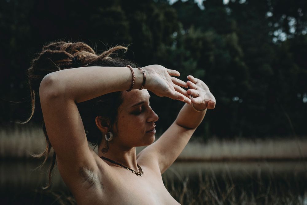 Foto colorida gravida, mãos a tapar o sol do rosto corpo nú sem aparecer os seios,  sessão gravida Portugal
