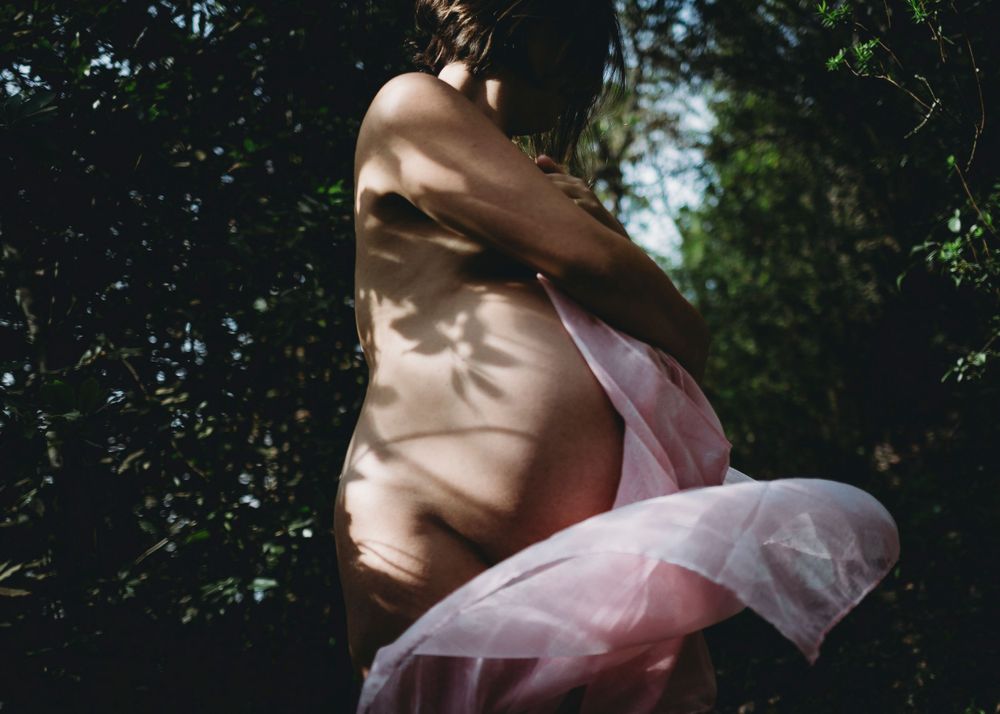 foto colorida grávida Nua na natureza a Dançar com lenço rosa durante sessão fotográfica de grávida em Caldas Da Rainha