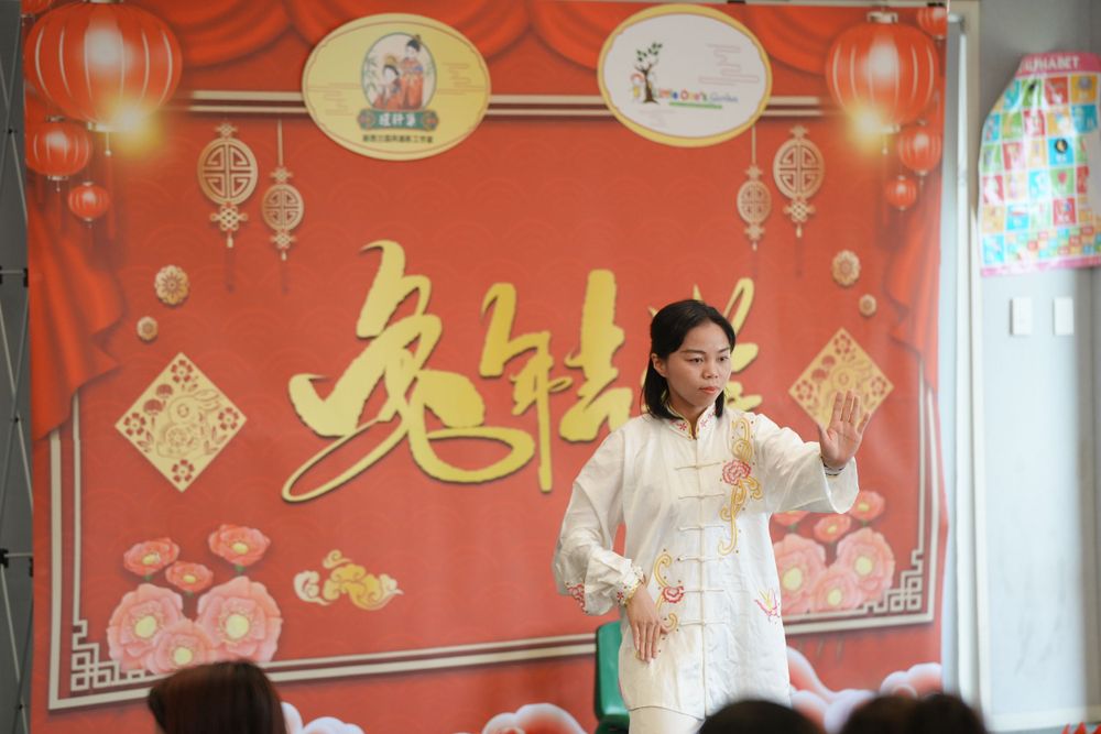 Event photography of a woman in Hanfu interacting with children at a kindergarten New Year party, by an Auckland event photographer.