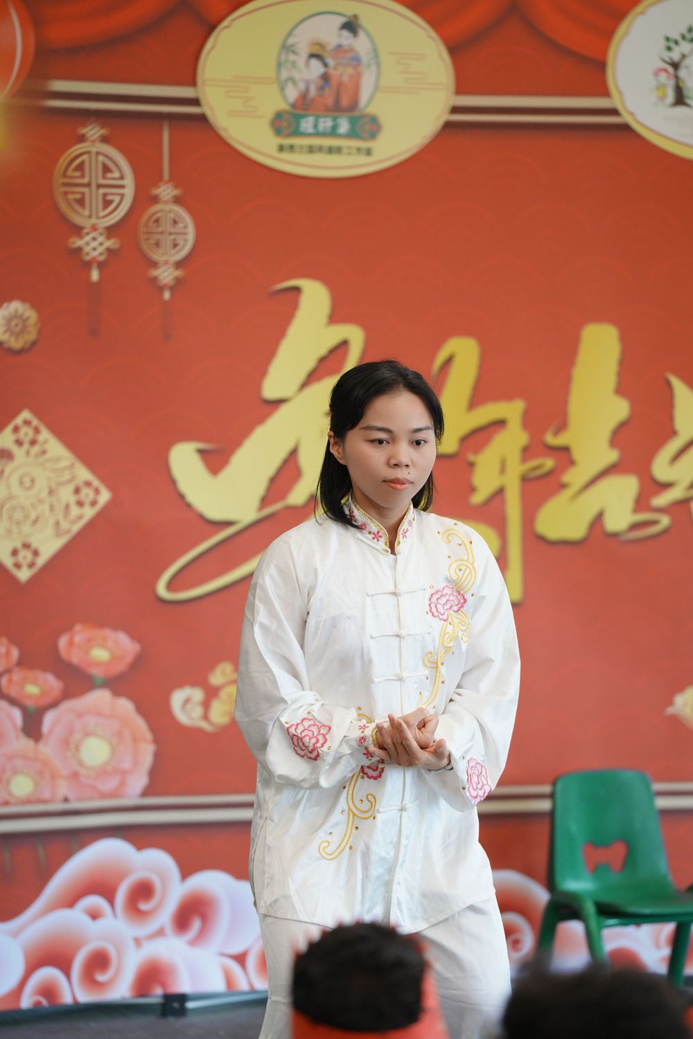Event photography of a woman in Hanfu interacting with children at a kindergarten New Year party, by an Auckland event photographer.