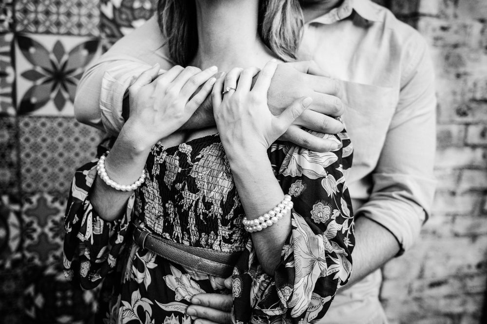 Black and white portrait of the couple hugging tightly in a garden.