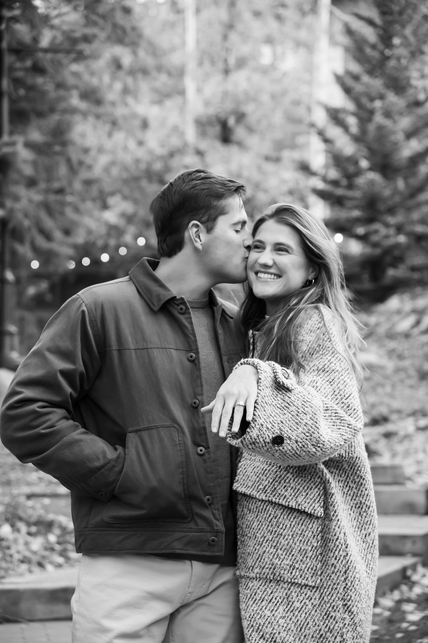 Cute couple showing off new engagement ring after a surprise proposal in Vail Village