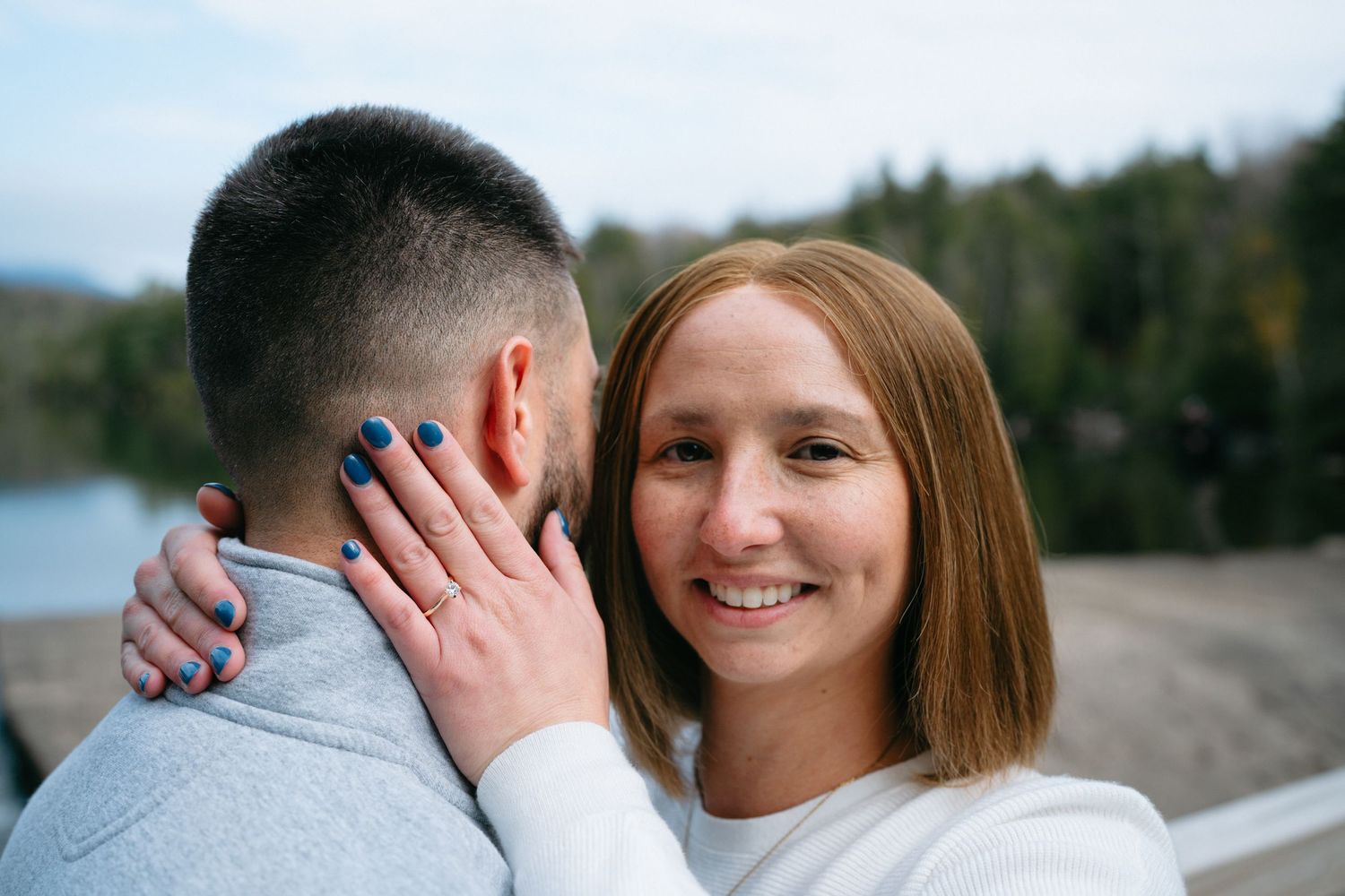 A tender moment captured between a couple during an autumn lakeside photoshoot.