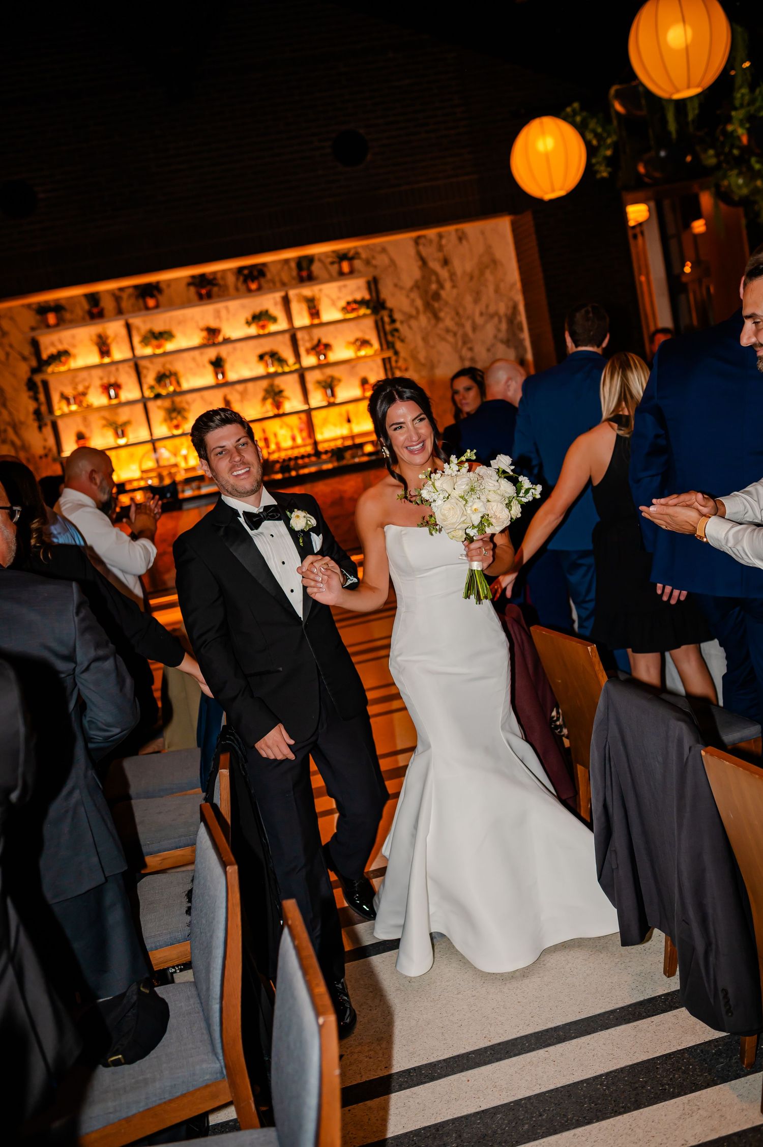 Wedding reception dance sequence showing couples swaying under orange paper lantern lighting.