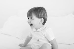 Candid black and white photo of child laughing and playing.