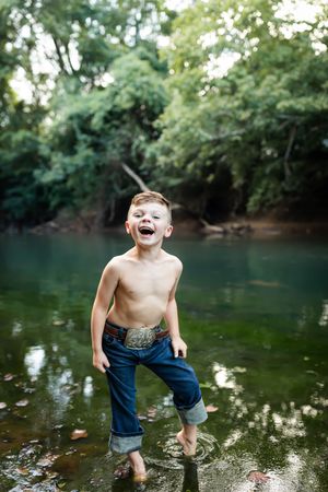 A joyful moment splashing and playing in a peaceful creek on a summer day.