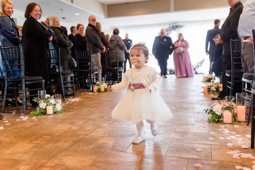 A couple shares their first dance at a wedding reception while guests watch from the perimeter of the dance floor.