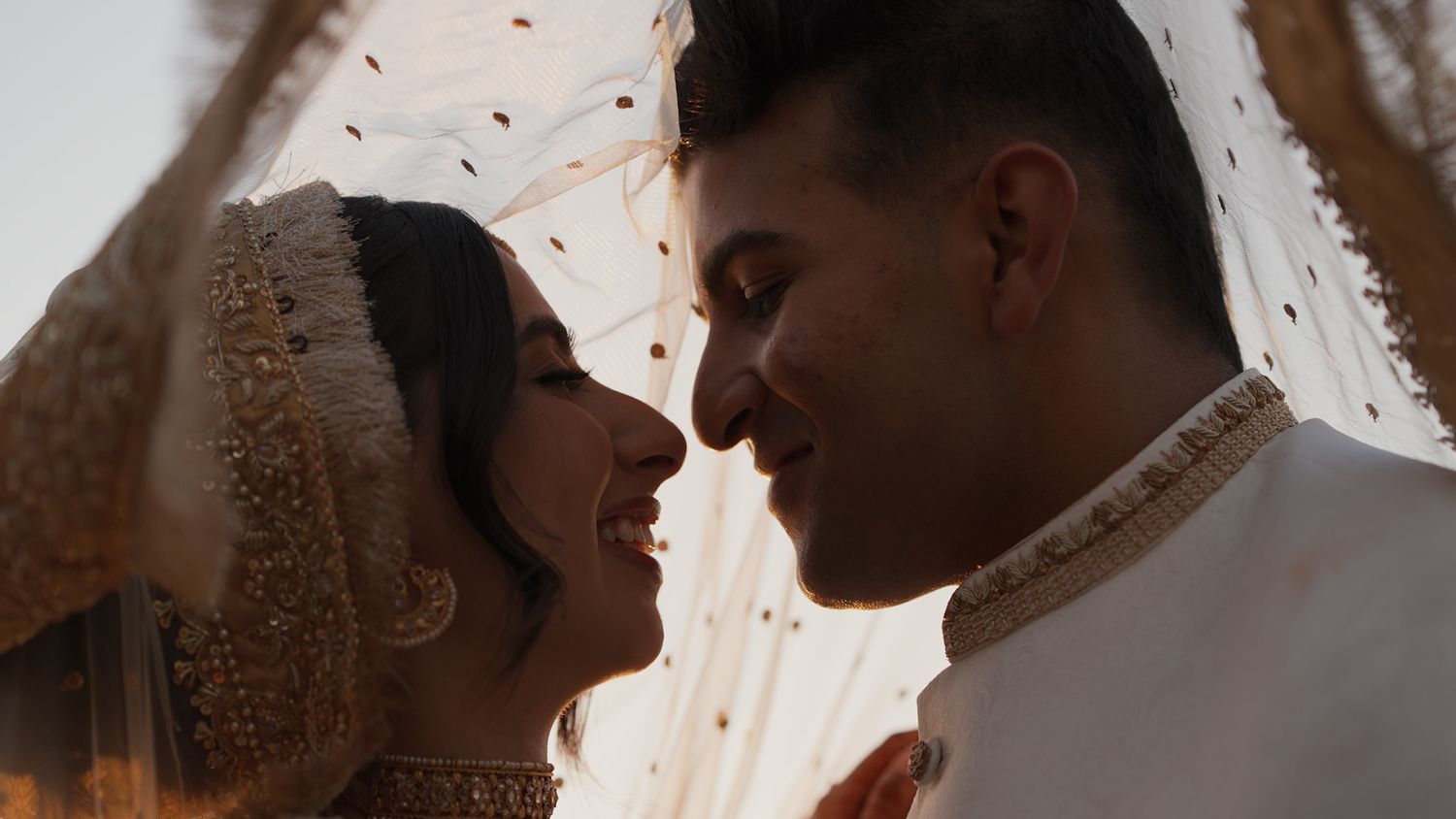 Romantic silhouette of a couple sharing an intimate moment under warm lighting.