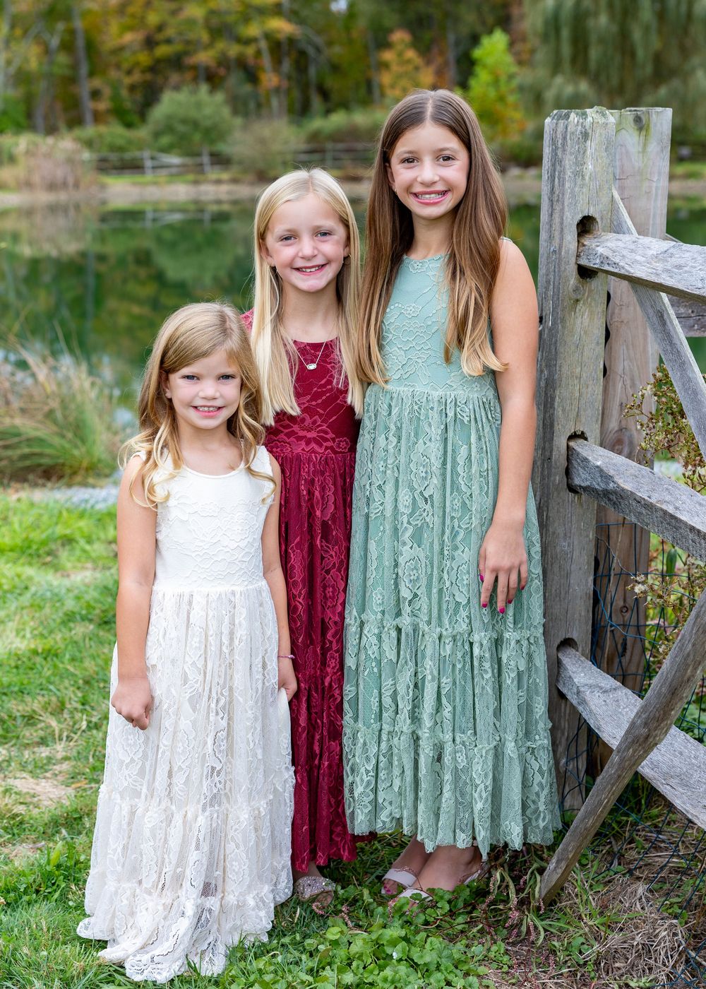 Siblings pose at a Mistletoe Christmas Tree Farm in Stow, MA (Metrowest) at holiday family photography session by Lisa West Photography.