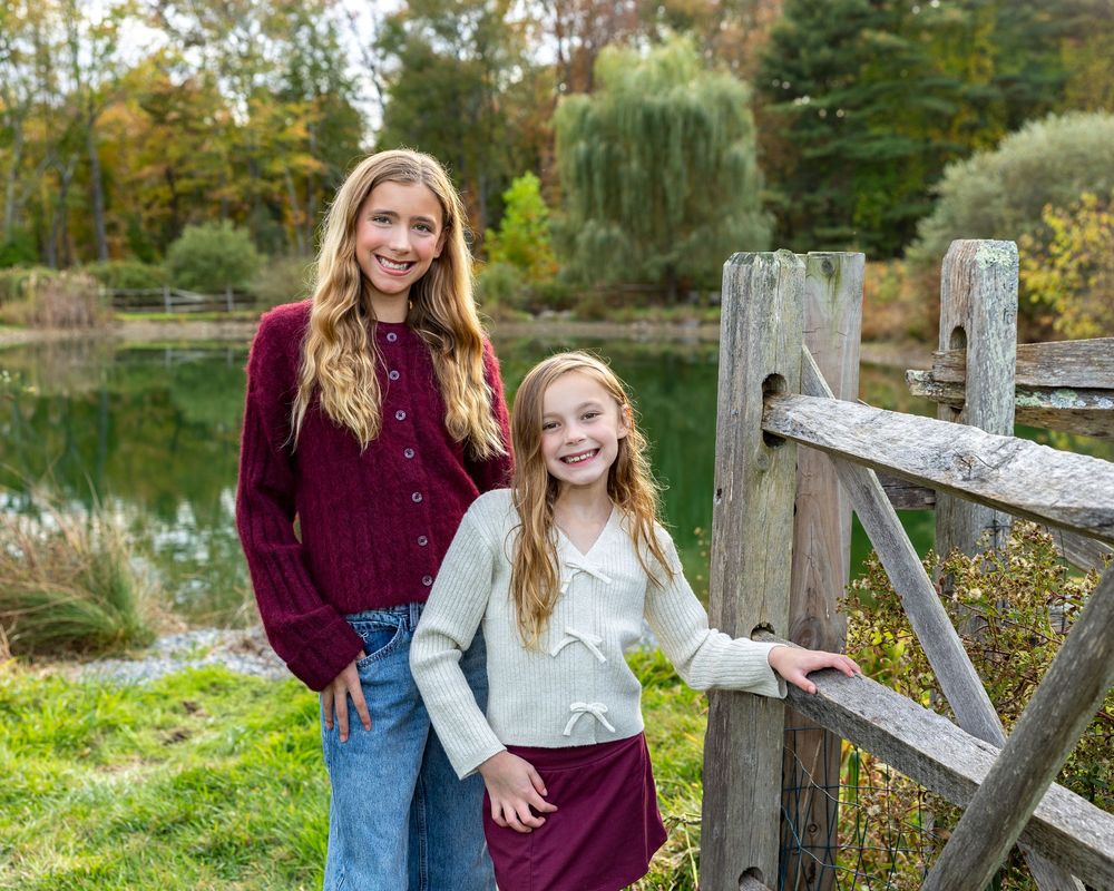 Siblings pose at a Mistletoe Christmas Tree Farm in Stow, MA at holiday family photography session by Lisa West Photography.