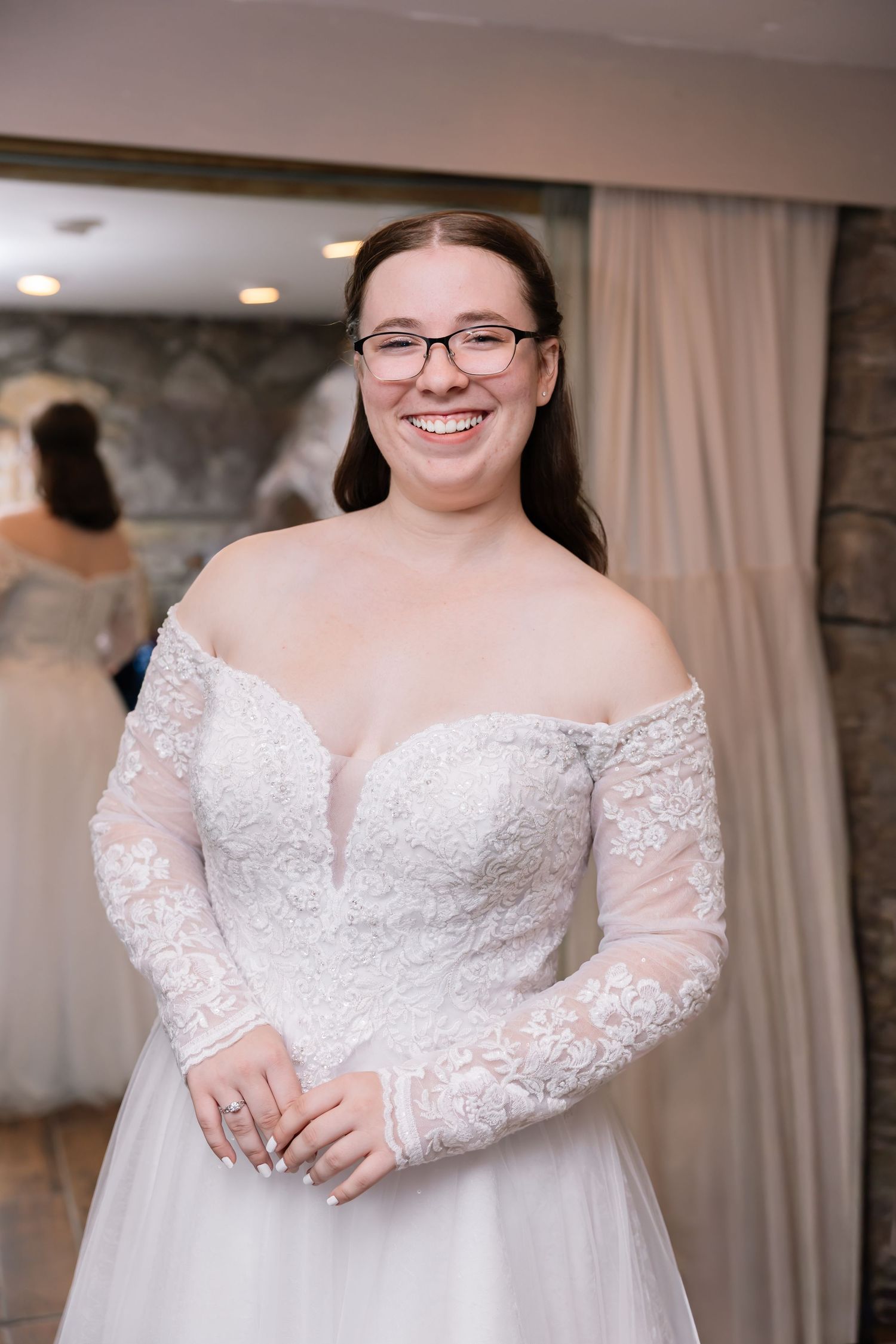 Close-up details of a white lace wedding dress with long sleeves and delicate beading.